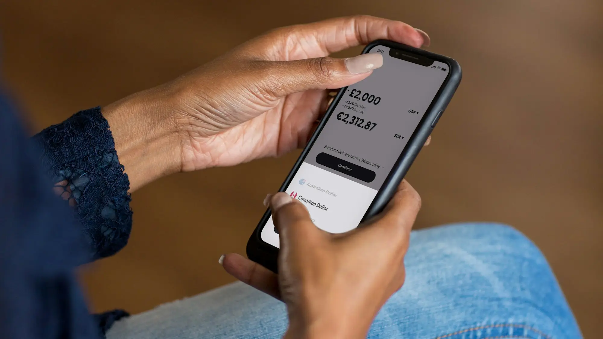 Hand holding a mobile phone showing a banking style app
