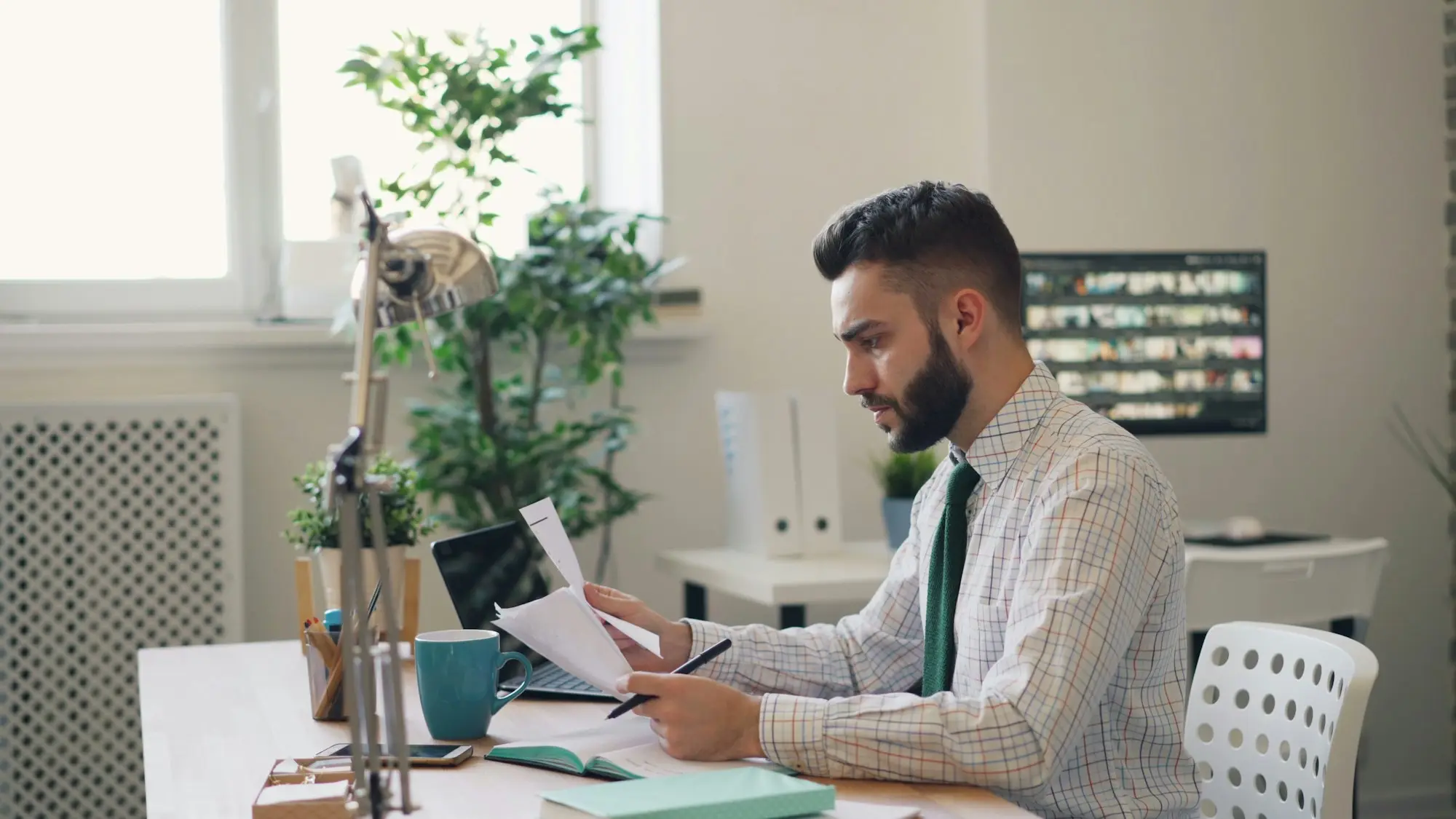 Business owner at a desk with a laptop and printed papers