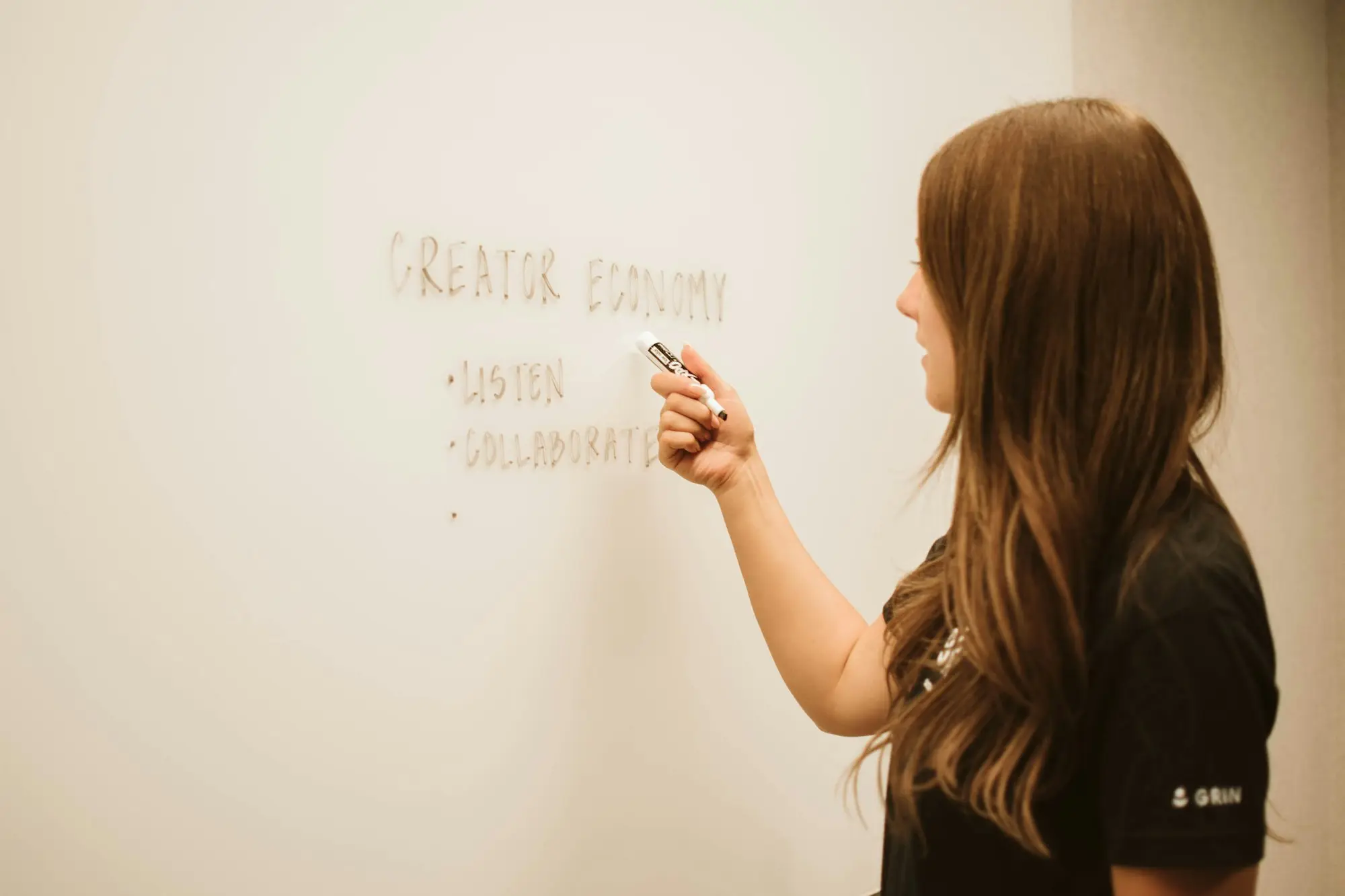 Woman writing options out on an office whiteboard