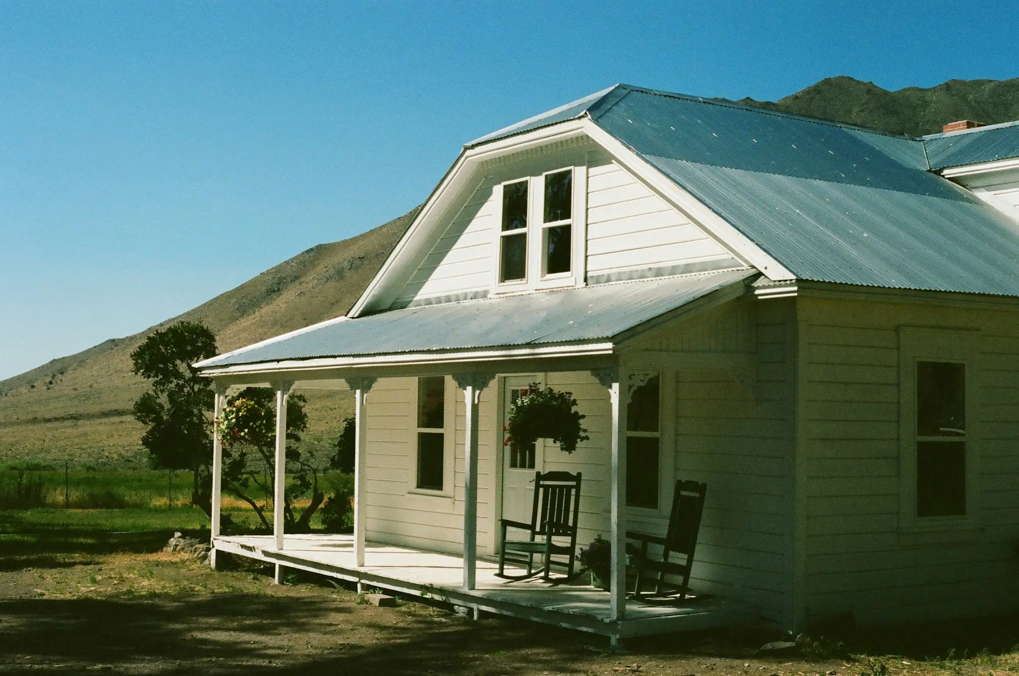 White weatherboard villa with a veranda and iron roof