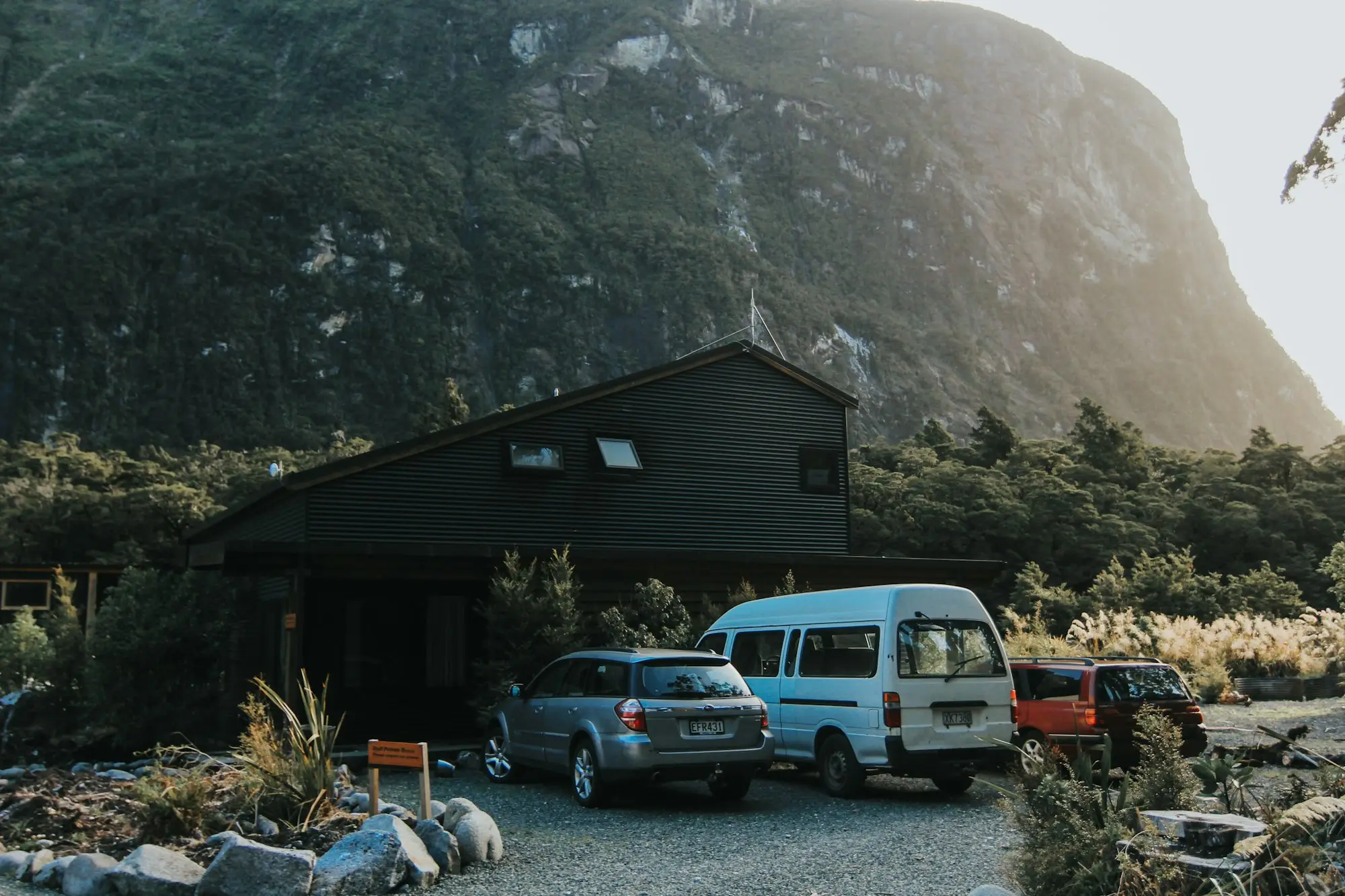Work vans parked outside a house below the hills